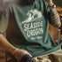Person wearing a green t-shirt with 'Seaside Oregon Ride a Wave' design.
